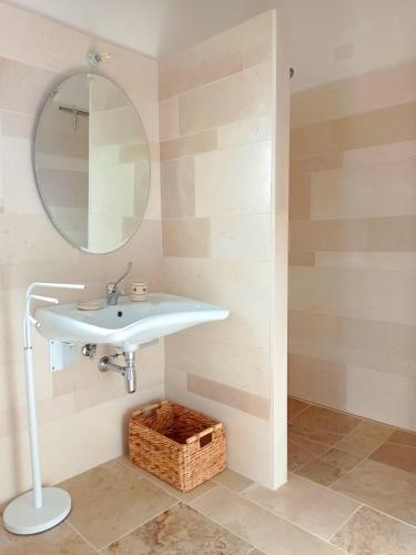 a bathroom with a sink and a mirror and a basket at Giardino Frannicola in Maglie