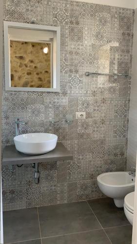 a bathroom with a sink and a toilet and a mirror at Casa castello in Rocca Imperiale