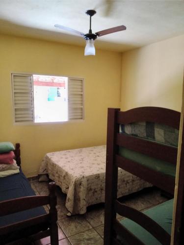 une chambre avec un lit et un ventilateur de plafond dans l'établissement Chácara meu doce, à Socorro