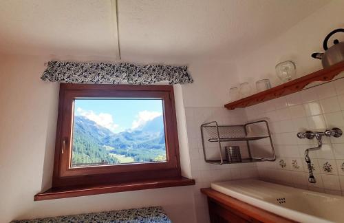 a bathroom with a window with a mountain view at Chalet Courmayeur in Courmayeur