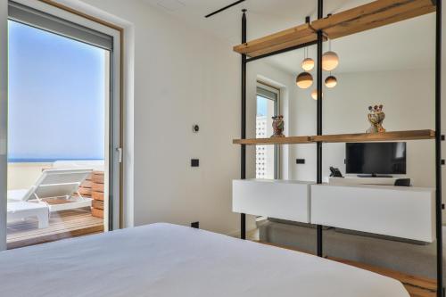 a bedroom with a white bed and a mirror at Abelia Sea Suites in Cefalù