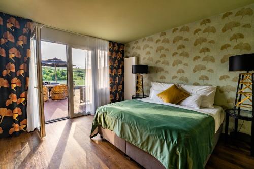 sypialnia z łóżkiem oraz balkon z patio w obiekcie Allure Healthy Hotel & Spa w Egerze