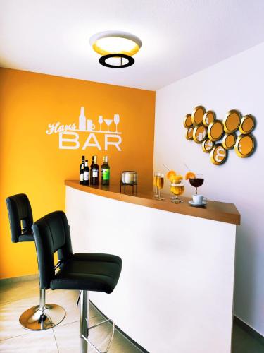 a bar with a black chair and bottles of wine at Hotel La Mirabelle close to Europa Park in Rheinhausen