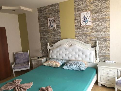 a bedroom with a large bed with a white headboard at Nesebar New Town Apartment in Nesebar
