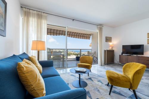 un salon avec un canapé bleu et des chaises dans l'établissement Sea View Park Swimming Pool & Tennis 2 Bdrs, à Villefranche-sur-Mer