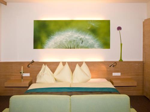 a bedroom with a bed with a painting on the wall at Hotel Moserhof in Seeboden