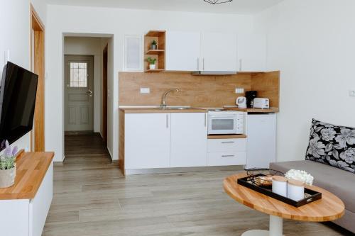 a kitchen with white cabinets and a table in a living room at Ilios house in Kavala