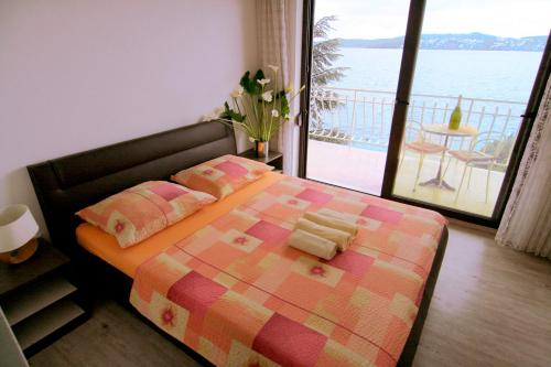 a bedroom with a bed with a view of the ocean at Apartments Marta in Trogir