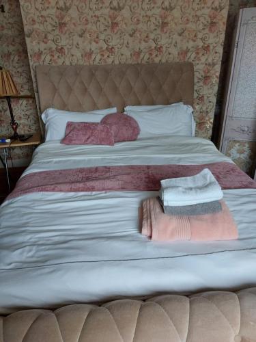 uma cama com duas almofadas e duas toalhas em Luglass house blueball em Blue Ball