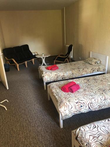 a room with three beds and a table and chairs at Hermes Külalistemaja in Võru