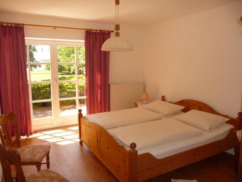 a bedroom with a bed and a large window at NTAB10001-FeWo-Moeoevwarder in Neue Tiefe Fehmarn