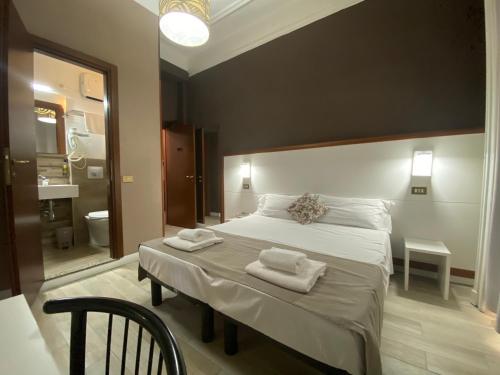 a bedroom with a large bed with towels on it at Hotel Bogart Milano in Milan