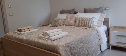a white bed with pillows and towels on it at Vesuvius' Lovely Inn in Ercolano