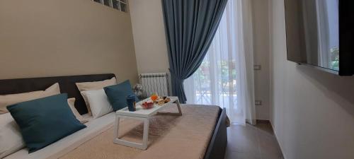 Un dormitorio con una cama con almohadas azules y una mesa. en Vesuvius' Lovely Inn, en Ercolano