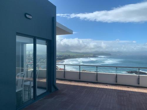 a balcony of a building with a view of the ocean at Monte Azul Penthouse in Ribeira Grande
