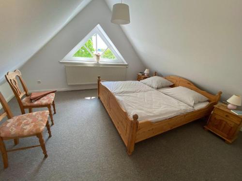 a bedroom with a bed and a chair and a window at NTAB10104-FeWo-Moeoevwarder-veer in Neue Tiefe Fehmarn