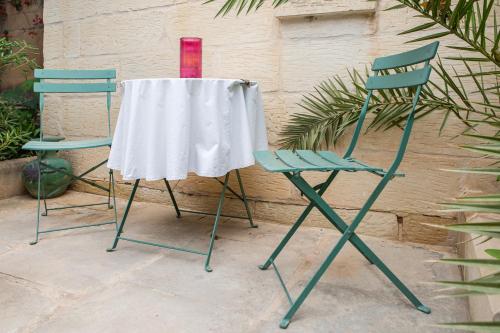 two chairs and a table with a red candle on it at Ta' Bertu Host Family Bed & Breakfast in Ħal Far
