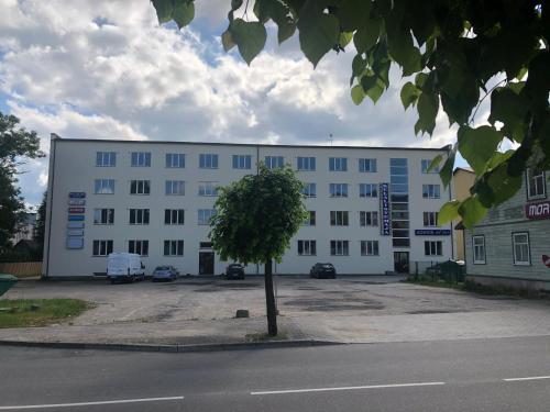 a white building with a tree in front of it at Hermes Külalistemaja in Võru