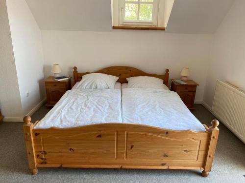 a bedroom with a wooden bed with two night stands at NTAB10105-FeWo-Moeoevwarder-fief in Neue Tiefe Fehmarn