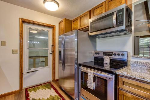 a kitchen with a stainless steel refrigerator and a microwave at Pigeon Forge Getaway, Hot Tub, Game Room, Wifi, 560 FREE tickets each paid day! in Pigeon Forge