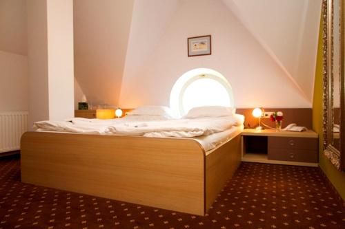 a bedroom with a large bed with an arched window at Hotel Zámek Berchtold in Kunice - Vidovice