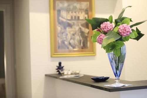 a vase with pink flowers sitting on a shelf at B&B Costa degli Dei in Tropea