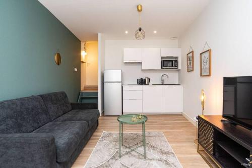 un salon avec un canapé et une table et une cuisine dans l'établissement ART & DECO - STUDIO COEUR DE VILLE, à Agen