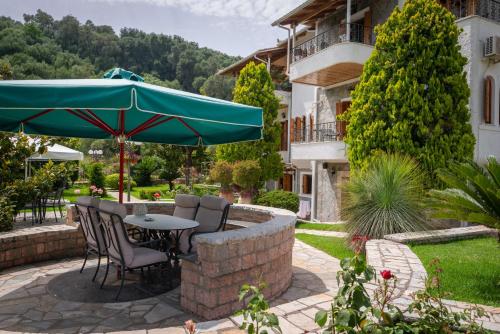 a patio with a table and chairs and an umbrella at Villa Haroula in Parga