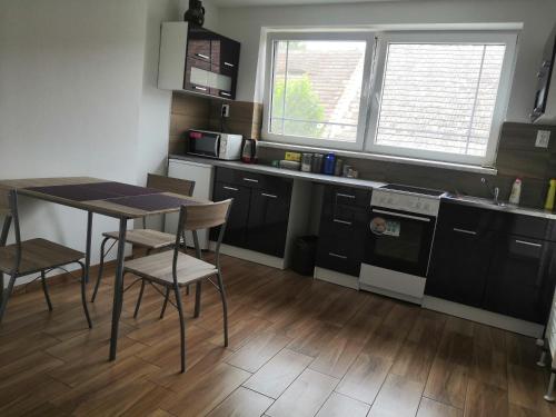 a kitchen with black cabinets and a table and chairs at U Moto Makovic in Horažďovice