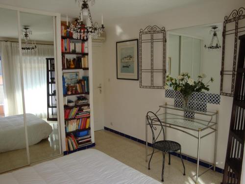 - une chambre avec un bureau, un lit et un miroir dans l'établissement les terrasses du Suquet, à Cannes