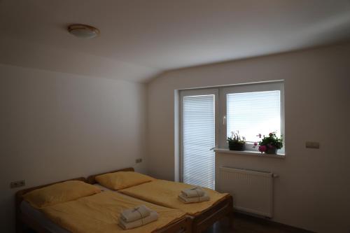 a bedroom with two beds and a window at Rezidencia Podhájska in Podhájska