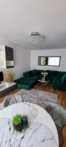 - un salon avec une table et un canapé vert dans l'établissement Apartament na wydmie u Eli, à Ustka