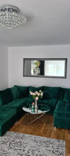 - un salon avec un canapé vert et une table dans l'établissement Apartament na wydmie u Eli, à Ustka
