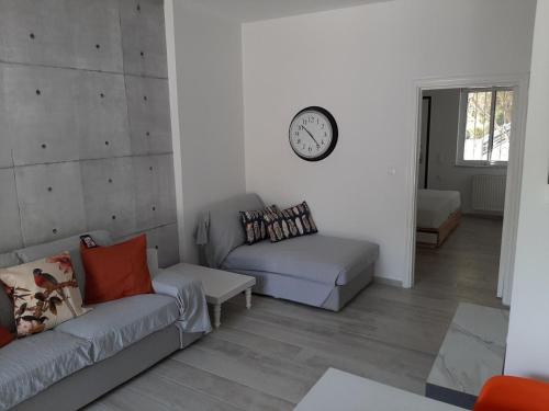 - un salon avec un canapé et un réveil sur le mur dans l'établissement My holiday home, à Rhodes
