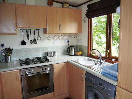 a kitchen with a stove top oven next to a sink at Bend in the River Lodge in Stratford-upon-Avon