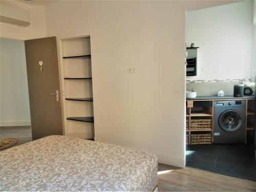 une chambre avec un lit et une cuisine avec un lave-linge dans l'établissement Appartement Triangle d Or plage-gareTGV-Mairie, à Saint-Raphaël