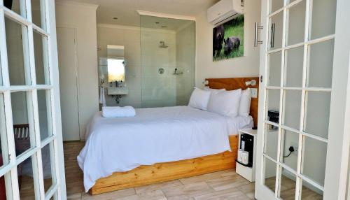 a bedroom with a white bed and a mirror at theLAB Robertson in Robertson
