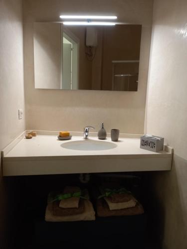 a bathroom with a sink and a mirror and towels at PETRA casa vacanza e non solo in Guspini