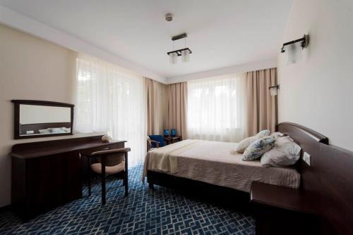 A bed or beds in a room at Villa Morskie Oko Niechorze