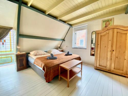 a bedroom with a bed and a table in it at The New Fisherman’s House in Zandvoort