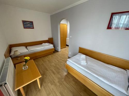 a room with two beds and a table at Hotel Laguna & restaurant in České Budějovice
