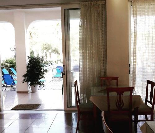 une salle à manger avec une table et des chaises ainsi qu'une terrasse dans l'établissement Hotel Petros, à Tsilivi