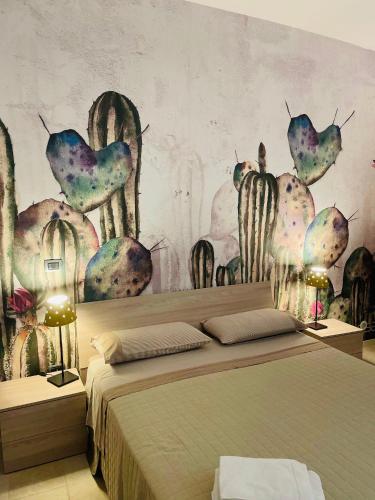a bedroom with a bed with a mural of cactus at Casetta San Domenico apartment in Monopoli
