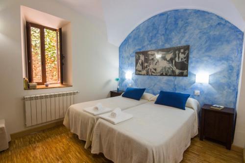 1 dormitorio con 1 cama grande y pared azul en La Posada de Grimaldo, en Grimaldo