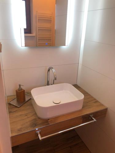 lavabo blanco en una encimera de madera en el baño en Krissun, en Pobierowo