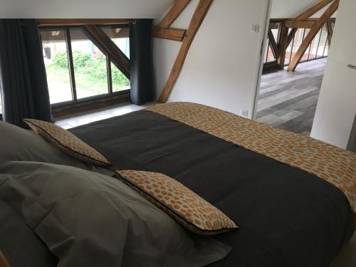 Un dormitorio con una cama grande con almohadas. en LES PORTES DE BOURGOGNE, en Serbonnes