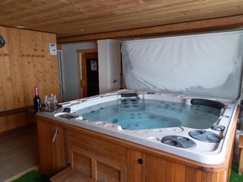 una gran bañera de hidromasaje en una habitación de madera en Auberge La Prairie, en Matemale