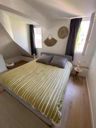 a bedroom with a large bed in a attic at duplex proche gare vue tour Perret avec parking gratuit in Amiens