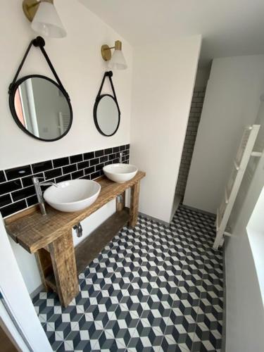 a bathroom with two sinks and a mirror on the wall at duplex proche gare vue tour Perret avec parking gratuit in Amiens