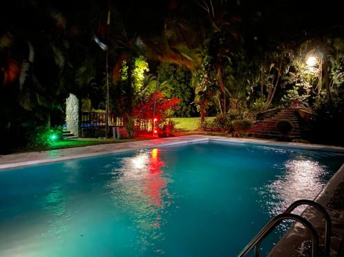 a swimming pool at night with lights in a yard at Plasencia Estate in Omoa